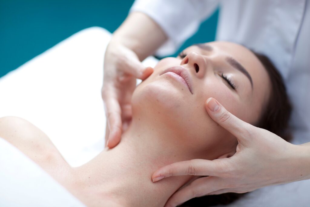 A woman receiving an acne facial massage as part of an aesthetics treatment for skin improvement.