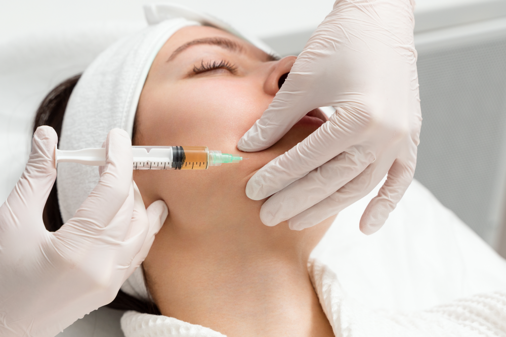 A professional administering Botox injections to a patient’s jawline in a clinical setting.